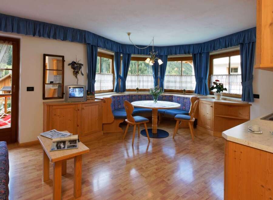 This charming property boasts a cozy dining area with a round table and built-in seating, perfect for intimate gatherings.