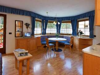 This charming property boasts a cozy dining area with a round table and built-in seating, perfect for intimate gatherings.