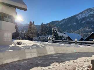 Experience the charm of winter in this stunning property! Nestled amidst a snowy landscape, this home offers breathtaking views of snow-covered mountains and lush evergreen trees.