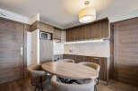This stunning property boasts a modern kitchen with sleek wooden cabinetry and a cozy dining area.