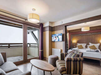 Experience luxury living in this stunning property, featuring a spacious living area with a cozy sofa and a modern TV.