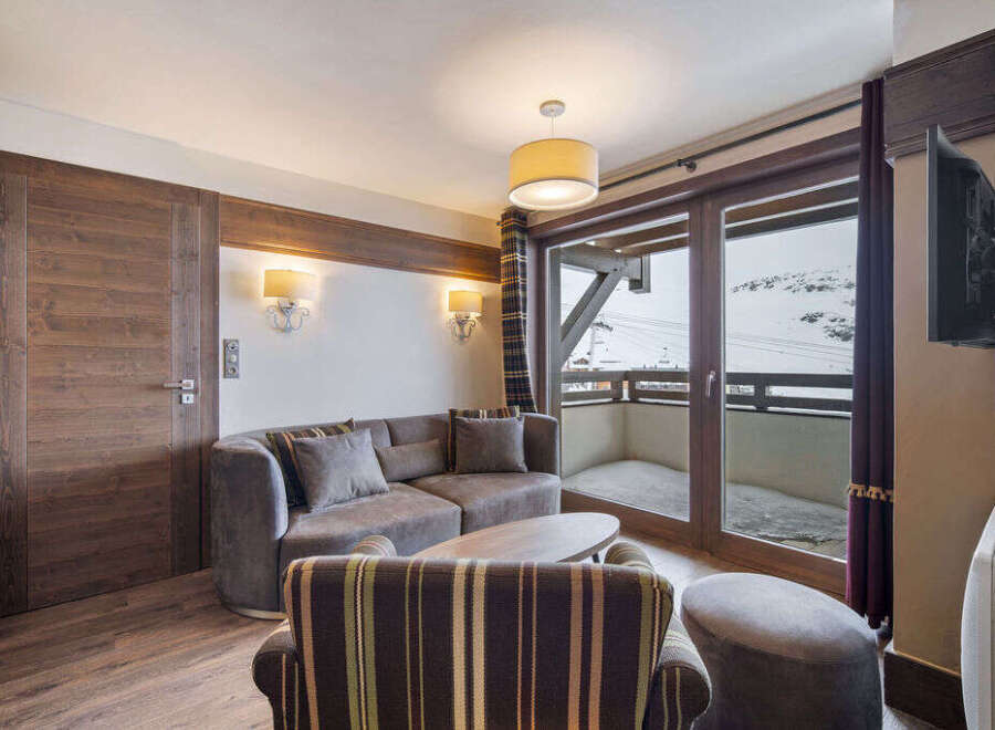 Experience luxury living in this stunning property, featuring a cozy living room with a comfortable sofa and a stylish armchair.
