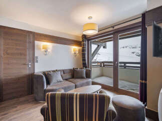 Experience luxury living in this stunning property, featuring a cozy living room with a comfortable sofa and a stylish armchair.