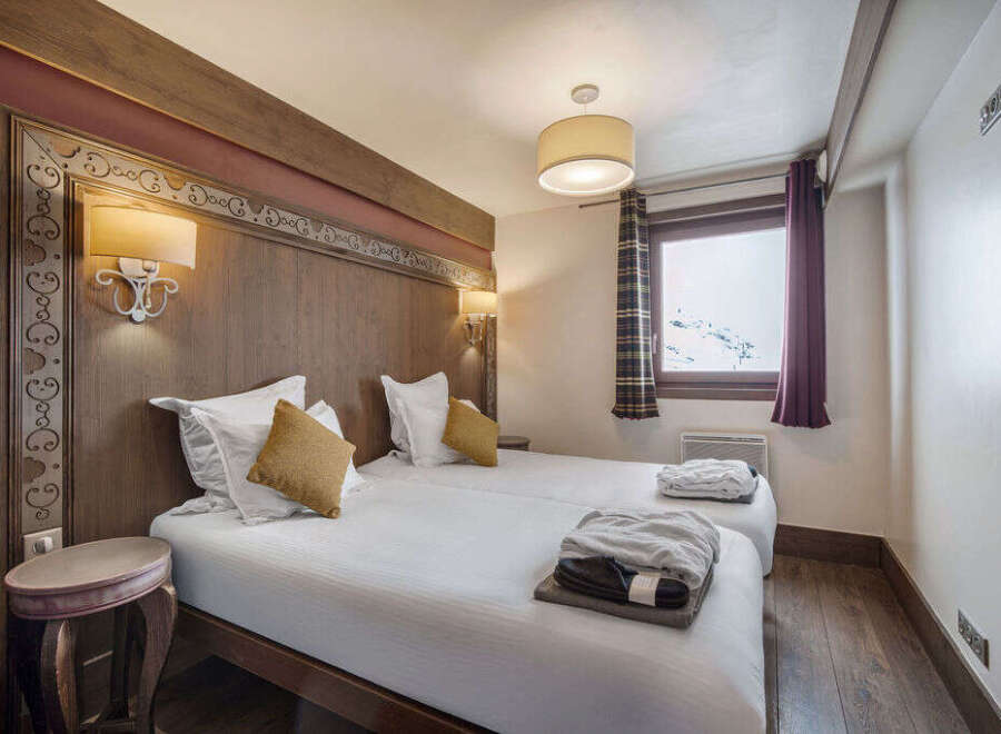 This cozy bedroom features two twin beds with crisp white linens and accent pillows.