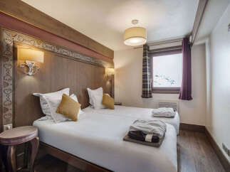 This cozy bedroom features two twin beds with crisp white linens and accent pillows.