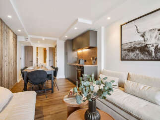 Discover modern living in this stylish apartment, featuring a sleek kitchen and a cozy dining area perfect for entertaining.