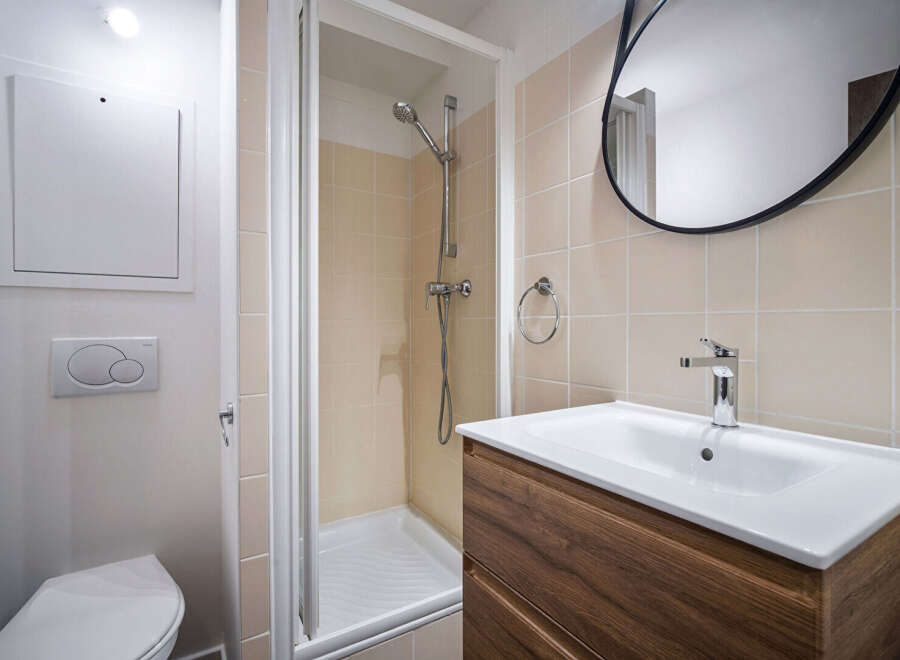 This modern bathroom features a sleek design with a walk-in shower and a stylish vanity.