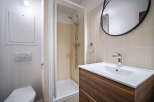 This modern bathroom features a sleek design with a walk-in shower and a stylish vanity.