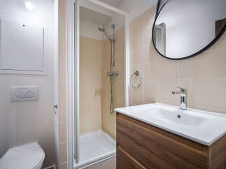 This modern bathroom features a sleek design with a walk-in shower and a stylish vanity.