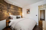 Experience the warmth and charm of this cozy bedroom, featuring a stunning wooden accent wall that adds a touch of rustic elegance.