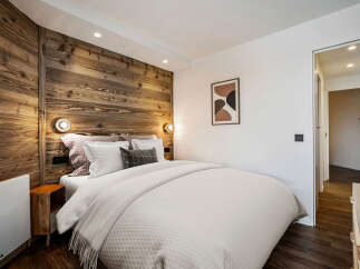 Experience the warmth and charm of this cozy bedroom, featuring a stunning wooden accent wall that adds a touch of rustic elegance.