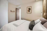 This cozy bedroom offers a serene retreat with its neutral color palette and inviting ambiance.