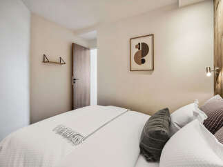 This cozy bedroom offers a serene retreat with its neutral color palette and inviting ambiance.