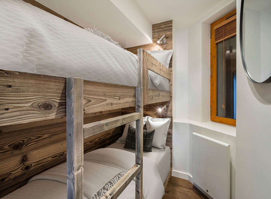 This cozy bedroom features custom-built bunk beds with rustic wooden frames, perfect for maximizing space.