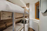 This cozy bedroom features custom-built bunk beds with rustic wooden frames, perfect for maximizing space.