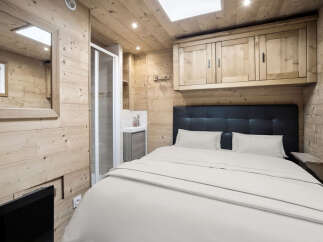 This cozy bedroom features a rustic wooden interior, creating a warm and inviting atmosphere.