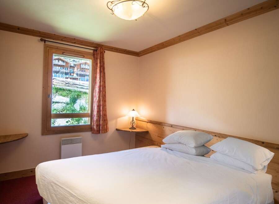 This cozy bedroom features a comfortable bed with crisp white linens, perfect for a relaxing stay.