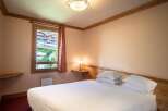This cozy bedroom features a comfortable bed with crisp white linens, perfect for a relaxing stay.
