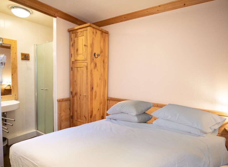This charming bedroom offers a cozy and inviting atmosphere, perfect for a relaxing getaway.