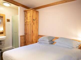 This charming bedroom offers a cozy and inviting atmosphere, perfect for a relaxing getaway.
