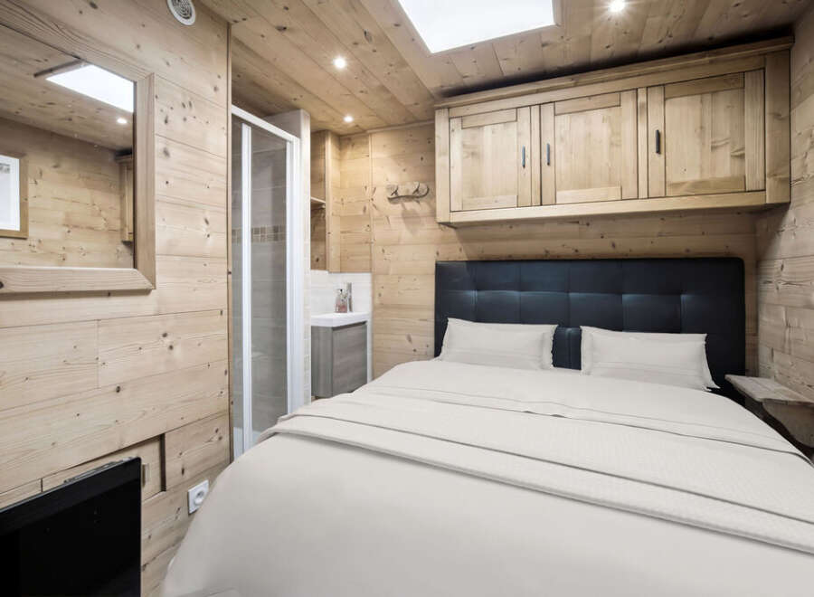 This cozy bedroom features a rustic wooden interior, creating a warm and inviting atmosphere.