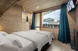 Experience the charm of this cozy bedroom, featuring warm wooden accents and a comfortable bed.
