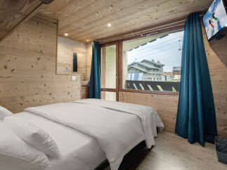 Experience the charm of this cozy bedroom, featuring warm wooden accents and a comfortable bed.