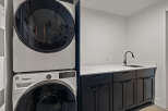 This modern laundry room features a sleek design with a stacked Whirlpool washer and dryer, offering both style and functionality.