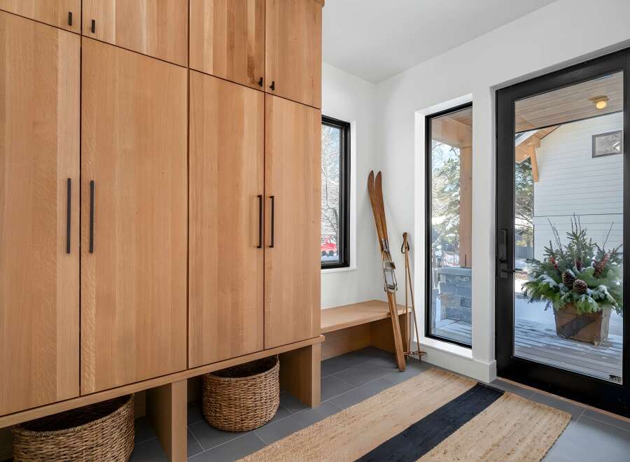 This stunning entryway showcases a custom wooden storage unit, perfect for organizing gear.