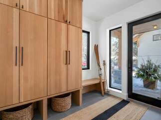 This stunning entryway showcases a custom wooden storage unit, perfect for organizing gear.