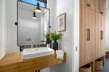 This modern bathroom features a sleek, minimalist design with a floating wooden vanity and a rectangular sink.