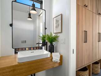 This modern bathroom features a sleek, minimalist design with a floating wooden vanity and a rectangular sink.
