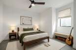 This inviting bedroom features a modern design with clean lines and a neutral color palette, creating a serene and relaxing atmosphere.