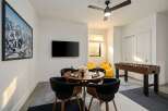 This modern game room features a stylish round table with comfortable chairs, perfect for gatherings.