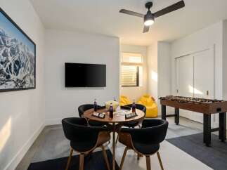 This modern game room features a stylish round table with comfortable chairs, perfect for gatherings.