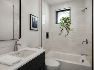 This modern bathroom features a sleek design with a white color scheme and a touch of nature.