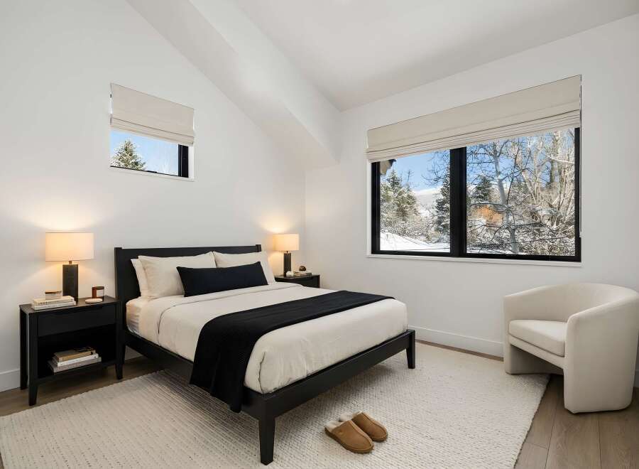 This stunning bedroom offers a serene retreat with its minimalist design and natural light.