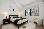 This stunning bedroom offers a serene retreat with its minimalist design and natural light.