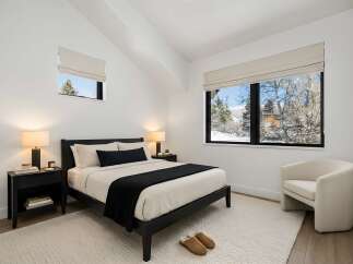 This stunning bedroom offers a serene retreat with its minimalist design and natural light.