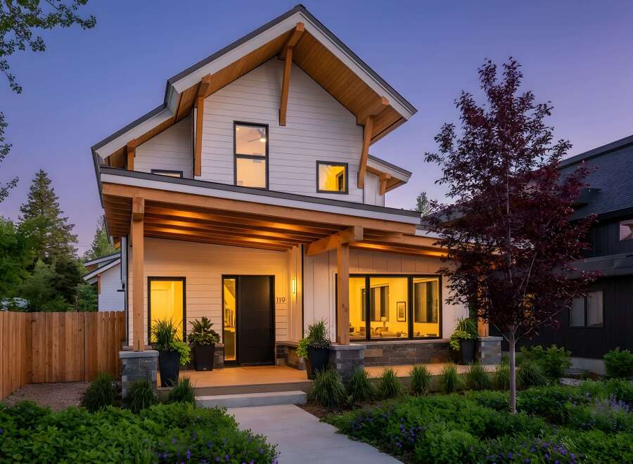 This stunning modern home boasts a striking exterior with a combination of white siding and natural wood accents.
