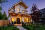 This stunning modern home boasts a striking exterior with a combination of white siding and natural wood accents.