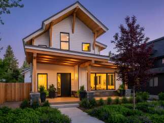 This stunning modern home boasts a striking exterior with a combination of white siding and natural wood accents.