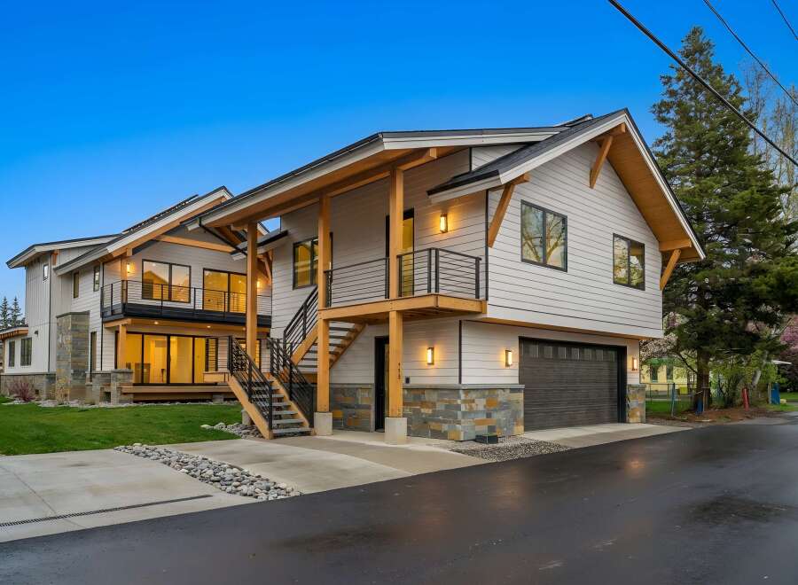 Experience modern living in this stunning multi-level home featuring a sleek exterior with natural wood accents and stone detailing.