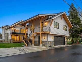 Experience modern living in this stunning multi-level home featuring a sleek exterior with natural wood accents and stone detailing.