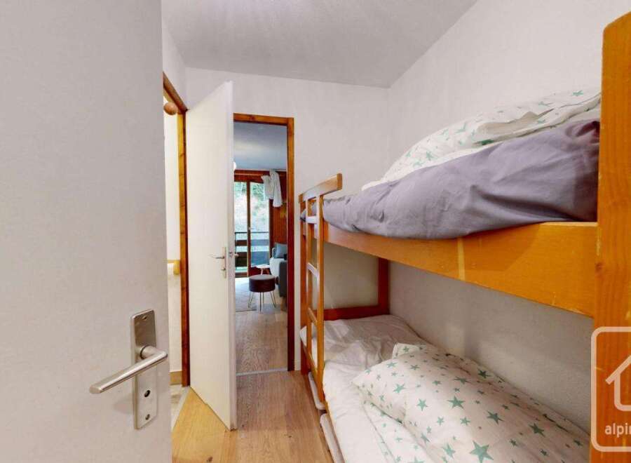 This cozy bedroom features a charming bunk bed, perfect for accommodating guests or family members.