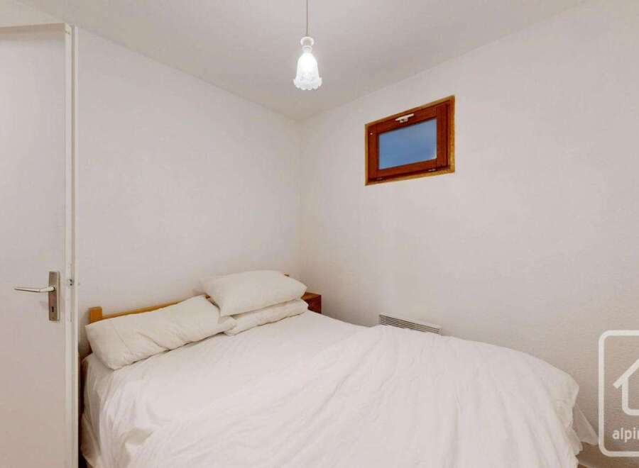 This cozy bedroom features a comfortable bed with soft bedding, perfect for a relaxing retreat.