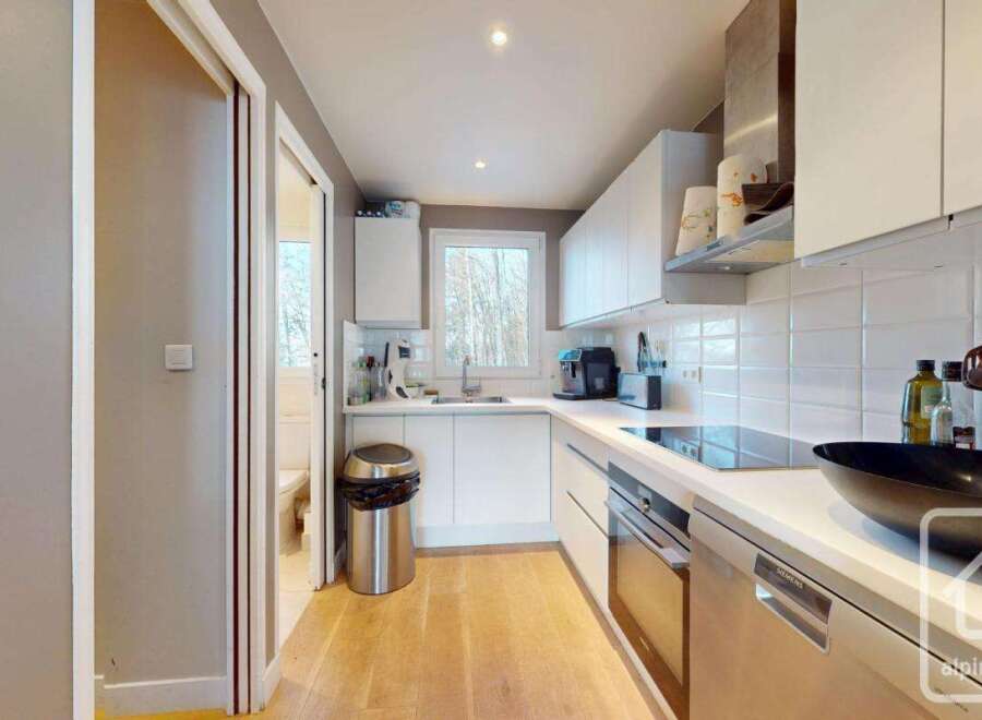 Discover this modern kitchen, featuring sleek white cabinetry and countertops, perfect for culinary enthusiasts.