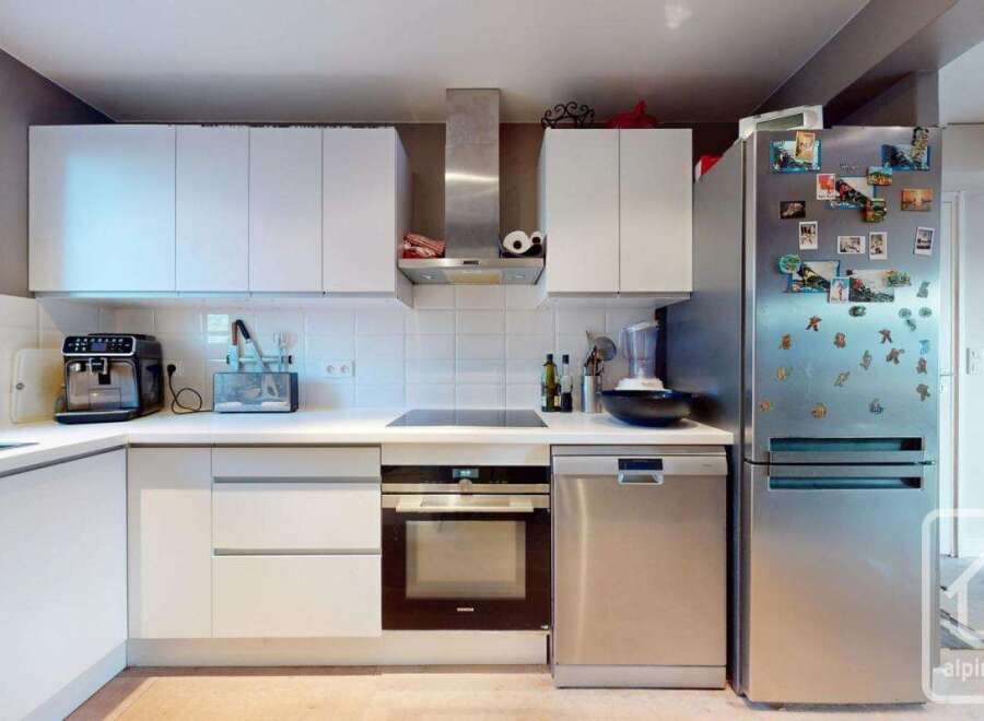 This modern kitchen boasts sleek white cabinetry, stainless steel appliances, and a minimalist design.