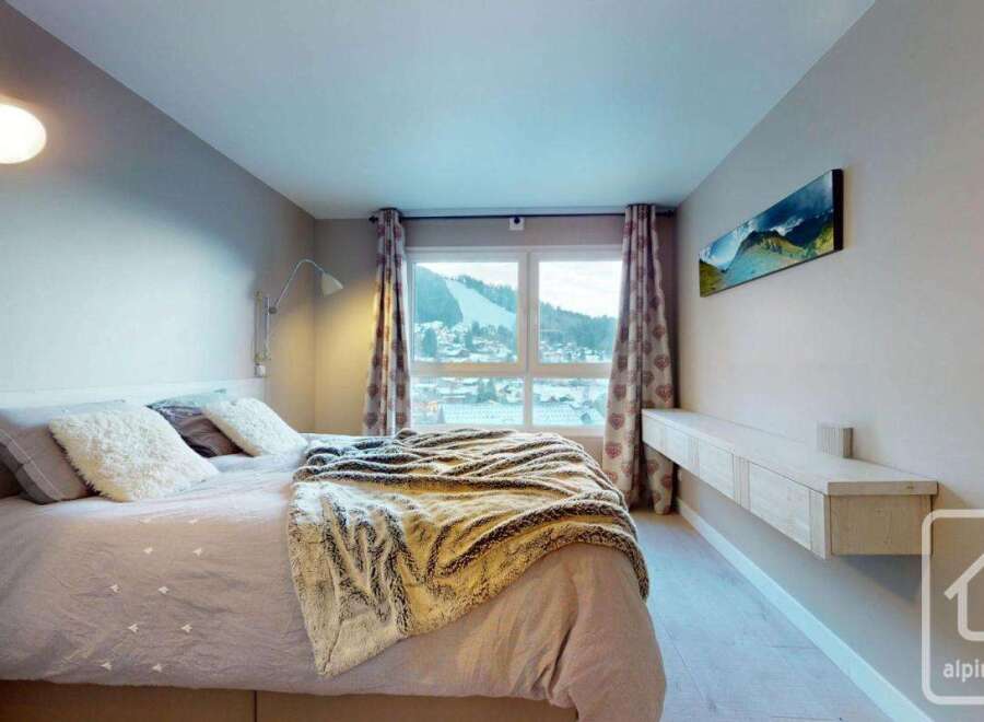 This cozy bedroom offers a serene retreat with its neutral color palette and inviting ambiance.