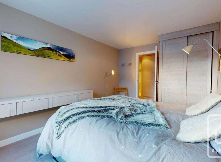 This cozy bedroom features a comfortable bed with soft bedding and a stylish throw blanket.